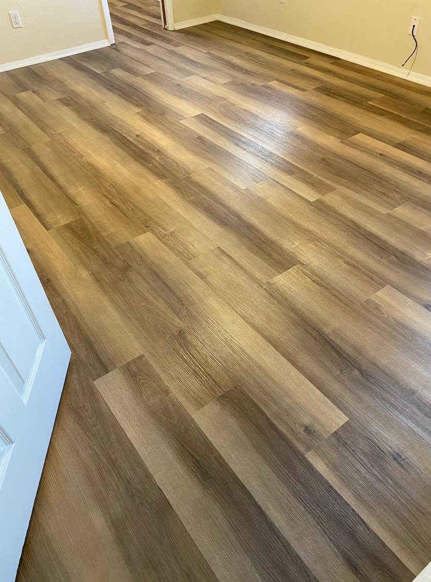 Close-up of warm-brown wood-look vinyl plank flooring showing varied plank tones and finish