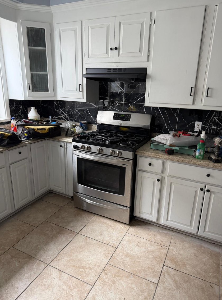 Kitchen with white cabinets and a black marble backsplash