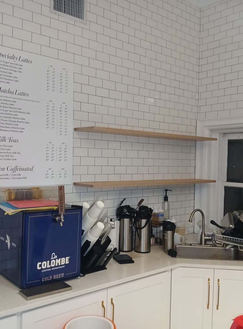 Coffee shop interior with subway tile, dark counter, and espresso machine